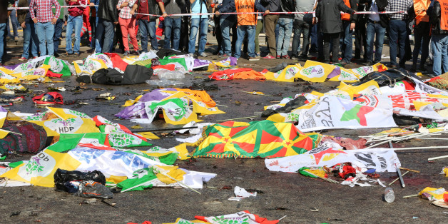 Bodies of victims are covered with flags and banners at the site of an explosion in Ankara, Turkey, Saturday, Oct. 10, 2015. Turkey's health minister says two bomb explosions in the Turkish capital have killed scores of people. The explosions occurred minutes apart near Ankara's main train station as people were gathering for a rally, organized by the country's public sector workers' trade union and other civic society groups. The rally aimed to call for an end to the renewed violence between Ku