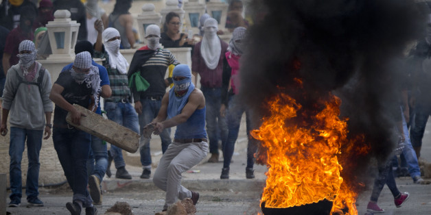 Palestinians improvise a barricade during clashes with Israeli troops near Ramallah, West Bank, Saturday, Oct. 10, 2015. Palestinians carried out two stabbing attacks in Jerusalem on Saturday before being shot dead by police, while another two Palestinians were killed during a violent demonstration near the Gaza border fence, the latest in a series of stabbing attacks against civilians and soldiers that have spread across Israel and the West Bank in the past week. The violence, including the fir