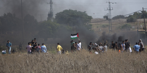 Palestinian protesters gather during clashes with Israeli soldiers on the Israeli border Eastern Gaza City, Friday, Oct. 9, 2015. At least four attacks â three by Palestinians and one by an Israeli â as well as deadly clashes along the Gaza border threatened to escalate tensions throughout the country on Friday as Israel struggled to control spiraling violence. (AP Photo/ Khalil Hamra)