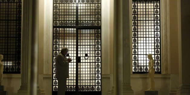 Greek State Minister Alekos Flampouraris uses his mobile phone outside of the gate of Maximos Mansion after Greek Prime Minister Alexis Tsipras announced the referendum in a televised address in central Athens, early Saturday, June 27, 2015. Greece's prime minister on Friday called a surprise referendum for July 5 on the financially troubled country's fraught bailout talks with international creditors, and government officials are calling on the nation to reject the proposed deal. (AP Photo/Petros Karadjias)
