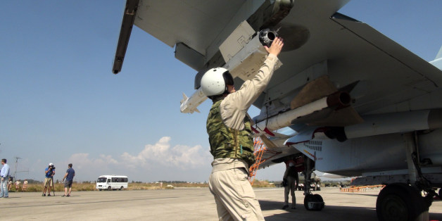 In this photo taken on Monday, Oct. 5, 2015, a Russian pilot fixes an air-to-air missile at his Su-30 jet fighter before a take off at Hmeimim airbase in Syria. NATO also strongly criticized the Russian air campaign in Syria that began Wednesday. (AP Photo/Dmitry Steshin, Komsomolskaya Pravda, Photo via AP)