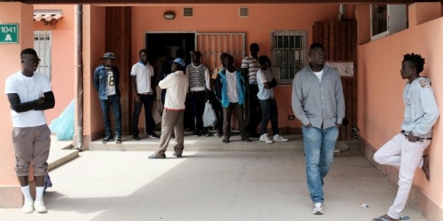 Des migrants attendent devant un centre d'accueil pour les demandeurs d'asile à Mineo, en Sicile, le 21 avril 2015
