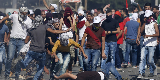 An injured Palestinian demonstrator is helped during clashes at the Hawara checkpoint near of the West Bank city of Nablus, Sunday, Oct. 11, 2015. Tensions in he West Bank continued with near-daily violent demonstrations. At least 45 Palestinians were wounded by live bullets in clashes between university students and Israeli forces at the military checkpoint near Nablus on Sunday, the Palestinian Health Ministry said. (AP Photo/Nasser Shiyoukhi)
