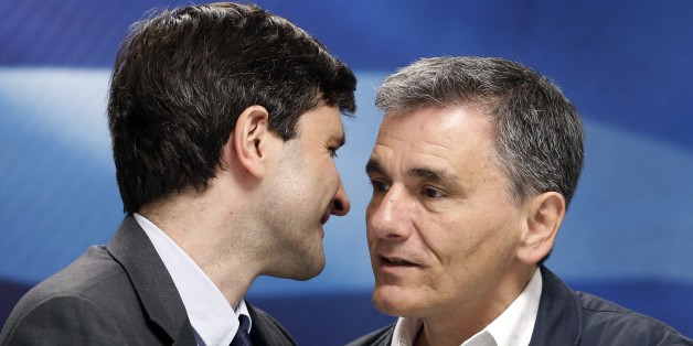Greek Finance Minister Giorgos Houliarakis, left, chats with outgoing Finance Minister Euclid Tsakalotos during a handover ceremony in Athens, Friday, Aug. 28, 2015. The new finance minister said his main target would be âto not waste valuable timeâ and strengthen the countryâs banking system as quickly as possible. (AP Photo/Petros Giannakouris)