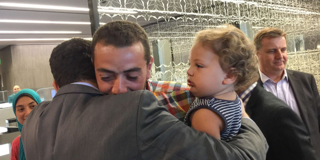 Egyptian Al-Jazeera English journalist Baher Mohammed, carrying his son Haroon, is welcomed by his colleagues upon his arrival to Doha, Qatar, Wednesday, Oct. 14, 2015. Baher and his Canadian colleague Mohamed Fahmy were among a group of 100 people pardoned by Egyptian President Abdel-Fattah el-Sissi on the eve of the major Muslim holiday of Eid al-Adha. (AP Photo)