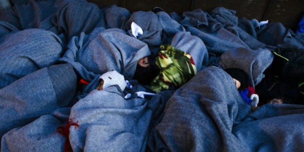 Des migrants endormis sous des couvertures sur le rivage de l'île de Lesbos le 15 octobre 2015 en provenance de Turquie