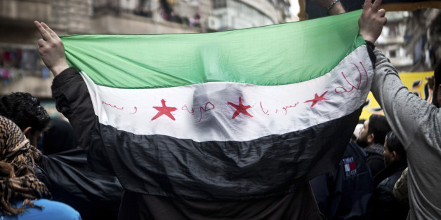 A Syrian carries a revolution flag during a Friday protest in Aleppo, Syria, where young people and children sang songs against Bashar Assad and the Syrian regime, Friday, Dec. 21, 2012.(AP Photo/Virginie Nguyen Hoang)