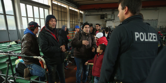 Flüchtlinge sprechen mit einem Polizisten in einem Erstaufnahmelager in Passau