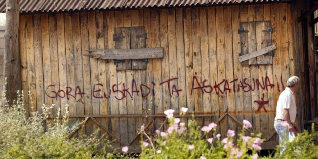 Un espagnol du village basque Llodio passe devant un graffiti "Euskadi Ta Askatasuna" (Pays basque et liberté), le 19 juin 2005