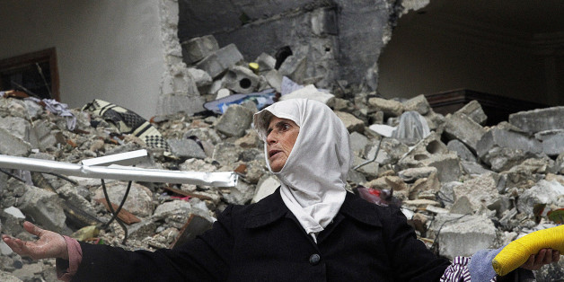 FILE - In this Wednesday, Feb. 6, 2013 file photo, a Syrian woman stands amid the ruins of her house which was destroyed in an airstrike by government warplanes a few days earlier, killing 11 members of her family, in the neighborhood of Ansari, Aleppo, Syria. President Bashar Assad has exploited his greatest advantage on the battlefield _ his air power _ to push back rebel advances and prevent the opposition from setting up a rival government in its northern stronghold. Along the way, fighter jets and helicopters bombed bakeries, makeshift hospitals and residential areas, according to a new report by a U.S.-based rights group released Thursday, April 11, 2013 accusing the regime of committing war crimes with indiscriminate airstrikes that have killed more than 4000 since summer. (AP Photo/Abdullah al-Yassin, File)
