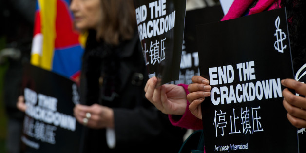 An Amnesty International supporter holds a sign with the slogan 'end the crackdown' in protest against claims of a deterioration in human rights and censorship of the internet and media during a state visit by Chinese President Xi Jinping