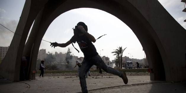 A Palestinian hurls a stone during clashes with Israeli troops, near Ramallah, West Bank, Tuesday, Oct. 20, 2015. U.N. Secretary-General Ban Ki-moon called for calm during a surprise visit to Jerusalem on Tuesday ahead of meetings with Israeli and Palestinian leaders, in a high-profile gambit to bring an end to a monthlong wave of violence. (AP Photo/Majdi Mohammed)