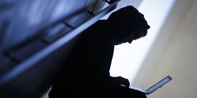 BERLIN, GERMANY - AUGUST 20: Symbolic feature with topic online crime, data theft and piracy and hacker, here the silhouette of a person with a laptop in his hands, on Augut 20, 2015 in Berlin, Germany. (Photo by Thomas Trutschel/Photothek via Getty Images)