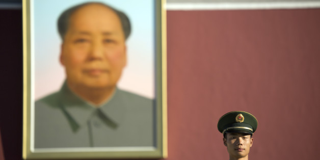 A Chinese guard stands on duty beneath the large portrait of former Chinese leader Mao Zedong on Tiananmen Gate after a flag raising ceremony on National Day, the 66th anniversary of the founding of the People's Republic of China, in Beijing, Thursday, Oct. 1, 2015. (AP Photo/Mark Schiefelbein)