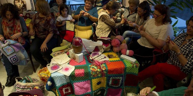 TO GO WITH AFP STORY BY DANIEL SILVA
Women knit blankets for Syrian people, at 'La Cafeteria' cafe in Villaverde del RÃo in on October 15, 2015. At home alone or hudled together in groups in cafes, women of all ages across Spain have furiously knitted blankets to send to war-torn Syria before cold weather starts in response to an online appeal for help. Every night for the past week, a team of some 20 women and girls have met in a café in the heart of Villaverde del Rio, a town of white-washed houses near Seville, to finish their blankets and send them to a small NGO of Madrid, Syrian People Support Association. AFP PHOTO/ CRISTINA QUICLER (Photo credit should read CRISTINA QUICLER/AFP/Getty Images)