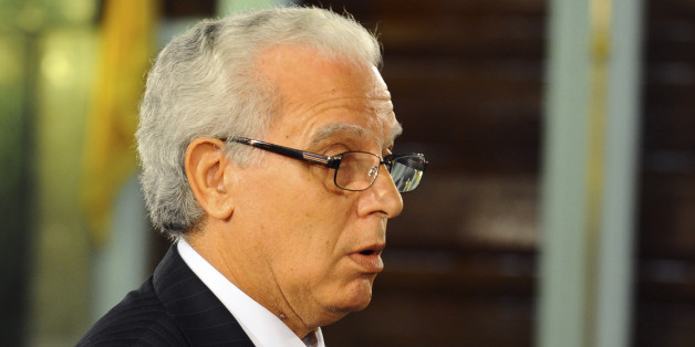 New Tunisian Justice Minister Mohamed Salah Ben Aissa takes the oath of office with his hand resting on the Quran, during a ceremony in Tunis, Friday, Feb. 6, 2015. Prime Minister Essid, whose cabinet has ministers from four parties including the powerful Islamist group, promised "work and nothing but work" on the country's economic and security problems.(AP Photo/Hassene Dridi)