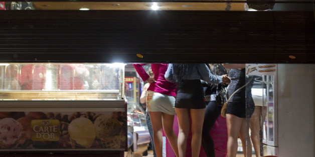 Prostitutes hide from riot police inside of a store during the eviction of a few activists who gathered at Puerta del Sol square to mark the anniversary of the "indignados" movement in Madrid, Spain, Tuesday, May 15, 2012. Spain got caught up in the uncertainty surrounding the European single currency and the electoral stalemate in Greece Monday as it saw its borrowing costs rise and stock prices fall at alarming rates. (AP Photo/Alberto Di Lolli)