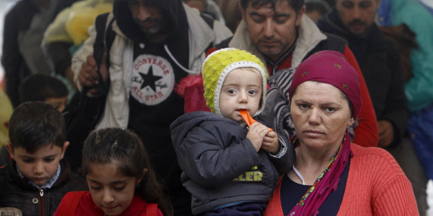 A woman carries a baby and arrives with others at the transit camp for refugees near the southern Macedonian town of Gevgelija, after crossing the border from Greece, on Thursday, Oct. 8, 2015. Several thousand migrants and refugees enter daily from Greece into Macedonia on their way through the Balkans towards the more prosperous European Union countries. More than 500,000 people have arrived this year in EU seeking sanctuary or jobs, sparking the EU's biggest refugee emergency in decades. (AP