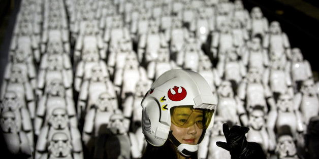A Chinese Star Wars fan dressed in costume poses for a photo in front of hundreds of miniature storm trooper figures placed atop the Juyongguan section of the Great Wall of China during a promotional event for the movie "Star Wars: The Force Awakens" outside of Beijing, Tuesday, Oct. 20, 2015. The film, the newest installment in the long-running Star Wars saga, opens in the U.S. in December. (AP Photo/Mark Schiefelbein)