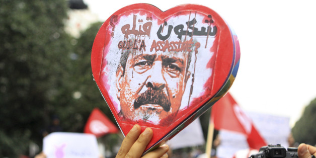 Demonstrators hold a poster showing slain opposition leader Chokri Belaid with written in arabic and french "Who Killed Him" during aTunisian demonstration on Habib Bourguiba avenue in downtown Tunis, Saturday, Feb. 23, 2013. Thousands of Tunisians joined a protest that started as a demonstration against what they described as a slow investigation into the death of assassinated opposition leader Chokri Belaid. (AP Photo/Amine Landoulsi)