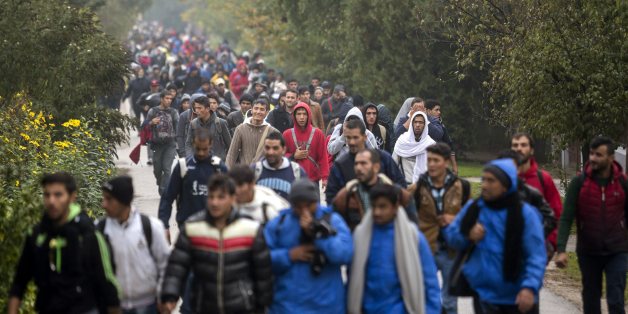 Migrants and refugees walk towards Austria at the former border station of Hegyeshalom, at the Austrian border, 169 kms west of Budapest, Hungary, Friday, Oct. 16, 2015. International Organization for Migration said that more than 600,000 people had arrived by sea into Europe this year and more than 3,000 of them died trying to reach Europe to escape war or poverty. (Balazs Mohai/MTI via AP)