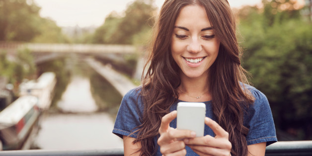 Young woman with smart phone on bridge.