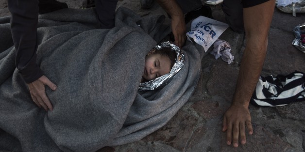 Paramedics and doctors care for a baby girl after a boat with refugees and migrants sunk while was crossing the Aegean sea from Turkey to the Greek island of Lesbos on Wednesday, Oct. 28, 2015. The condition of the child is not known. A 7-year-old boy died off Lesbos, where most migrants land, while a 12-month-old girl was in critical condition in hospital from the same boat accident. Greek authorities said Wednesday that at least five people, including four children, have drowned as thousands o