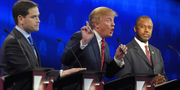 Donald Trump, center, makes a point as Marco Rubio, left, and Ben Carson look on during the CNBC Republican presidential debate at the University of Colorado, Wednesday, Oct. 28, 2015, in Boulder, Colo. (AP Photo/Mark J. Terrill)