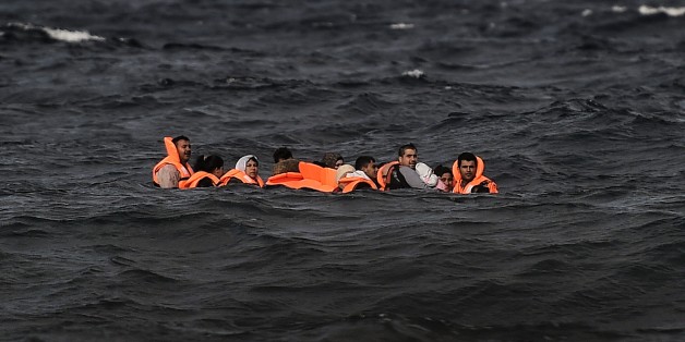 Refugees and migrants cross by boat the Aegean sea from Turkey, to reach the Greek island of Lesbos, on October 31, 2015. AFP PHOTO / ARIS MESSINIS (Photo credit should read ARIS MESSINIS/AFP/Getty Images)