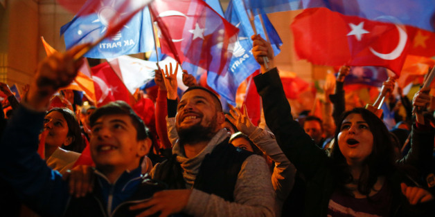 Supporters of Turkey's President Recep Tayyip Erdogan and The Justice and Development Party, (AKP), wave their party and national flags as they celebrates outside the AKP headquarters, in Istanbul, Sunday, Nov. 1, 2015. Tens of millions of Turkish voters cast ballots in a contest that will determine whether the ruling party can restore the parliamentary majority it had enjoyed for over a decade. (AP Photo/Emrah Gurel)