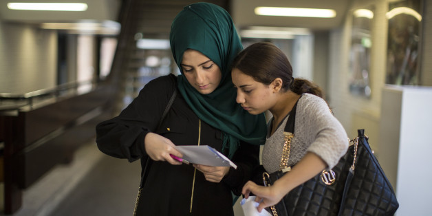 Zwei junge Frauen blicken auf die Resultate ihres Tests im Schulhaus
