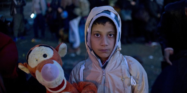 A young boy poses with a soft toy as migrants and asylum seekers wait to enter a registration camp near Gevgelija on October 26, 2015. The EU pledged to help set up 100,000 places in reception centres along the migrant route through the Balkans, in a bid to defuse rising tensions on its eastern frontier over how to deal with the crisis. AFP PHOTO / NIKOLAY DOYCHINOV (Photo credit should read NIKOLAY DOYCHINOV/AFP/Getty Images)