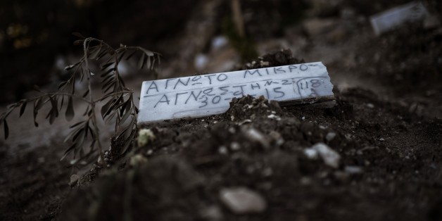TO GO WITH AFP STORY BY MARINA RAFENBERG
A piece of marble reading 'Unidentified child' is placed over the grave of a child who drowned on its way from Turkey to the Greek island of Lesbos, at a makeshift cemetery in Mytilene, on the island of Lesbos, on November 4, 2015. AFP PHOTO / ARIS MESSINIS (Photo credit should read ARIS MESSINIS/AFP/Getty Images)