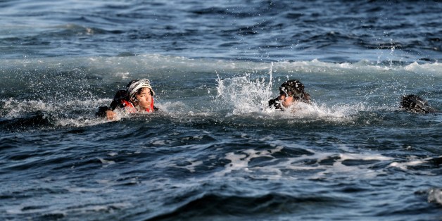 Refugees and migrants swim as they try to reach the shore of the Greek Lesbos island after crossing the Aegean Sea from Turkey on November 2, 2015. More than 218,000 migrants and refugees crossed the Mediterranean to Europe in October -- a monthly record and more than during the whole of 2014, the United Nations said Monday. AFP PHOTO / ARIS MESSINIS (Photo credit should read ARIS MESSINIS/AFP/Getty Images)