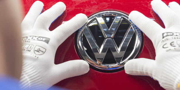 A worker checks the Volkswagen sign on a Golf car during the so called 'Open Door Day' to celebrate the 25th anniversary of the German manufacturer Volkswagen Sachsen in Zwickau, eastern Germany, Sunday, Sept. 6, 2015. More than 4.9 Million vehicles (Golf and Passat) have left the production facilities since foundation on the Zwickau plant in 1990. (AP Photo/Jens Meyer)