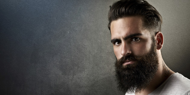 Portrait of a brutal bearded man with tattoos