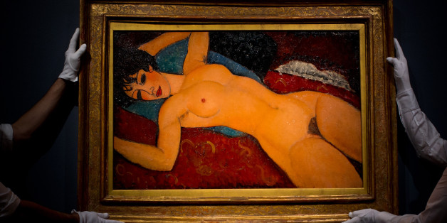 LONDON, ENGLAND - OCTOBER 09: Art handlers hang the painting 'Nu couche' by artist Amedeo Modigliani during the preview ahead of the artist's muse: a curated evening sale in Christie's New York on October 9, 2015 in London, England. The impressionist, modern, post-war and contemporary works will be on show to the public between October 10 and October 17 and includes Amedeo Modigliani's 'Nu couche' which is estimated to sell for 100 USD million. The sale also showcases pieces by artists including Lucian Freud, Paul Cezanne, Peter Doig, Pablo Picasso, Alberto Giacometti, Amedeo Modigliani and Roy Lichtenstein. (Photo by Ben Pruchnie/Getty Images)