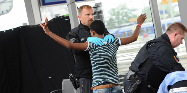 Ein junger Mann aus Eritrea wird am 02.09.2015 am Bahnhof in Rosenheim (Bayern) von einem Polizisten abgetastet. (Archivbild)