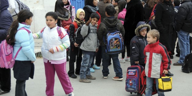 Schoolchildren wait outside their school in Tunis, Monday Jan. 24, 2010. Teachers across Tunisia have gone on strike to demand members of the former party of the ousted president stay out of power, on the day when schools were set to reopen after weeks of closure amid unrest and street protests. (AP Photo/Hassene Dridi)