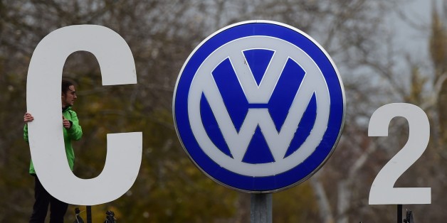 An activist of environmental organisation Greenpeace holds a giant letter to display 'CO2' around the logo of German car maker Volkswagen ( VW ) at the entrance of the company's headquarters in Wolfsburg, on November 9, 2015. VW is engulfed in a massive pollution scandal that has so far centred on so-called defeat devices, sophisticated software fitted into diesel engines to skew the results of tests for nitrogen oxide emissions. The embattled auto giant said an internal probe had uncovered 'inc