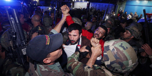 Lebanese soldiers arrest a suspected attacker attacker near the scene of a twin suicide attack in Burj al-Barajneh, southern Beirut, Lebanon, Thursday, Nov. 12, 2015 that struck a Shiite suburb killed and wounded dozens, according to a Lebanese official. (AP Photo/Bilal Hussein)