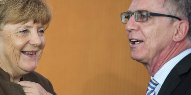 German Chancellor Angela Merkel (L) and interior minister Thomas de Maiziere speak as they arrive for the weekly cabinet meeting at the Chancellery in Berlin on October 28, 2015. AFP PHOTO / ODD ANDERSEN (Photo credit should read ODD ANDERSEN/AFP/Getty Images)