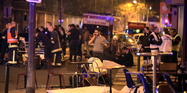 Victims lay on the pavement in a Paris restaurant, Friday, Nov. 13, 2015. Well over 100 people were killed in Paris on Friday night in a series of shooting, explosions. French President Francois Hollande declared a state of emergency and announced that he was closing the country's borders. (AP Photo/Thibault Camus)