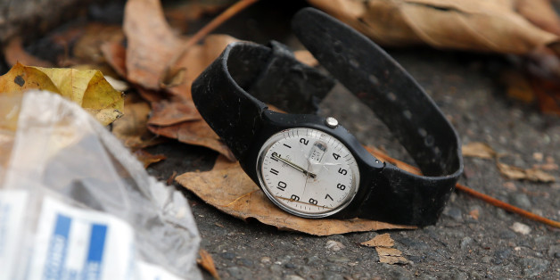 A watch lays on the ground outside the Bataclan concert hall, Saturday, Nov. 14, 2015 in Paris. French President Francois Hollande said more than 120 people died Friday night in shootings at Paris cafes, suicide bombings near France's national stadium and a hostage-taking slaughter inside a concert hall. (AP Photo/Christophe Ena)