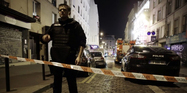 A policeman stands behind a cordon blocking the street near the site of an attack in a restaurant in Paris on November 13, 2015. At least 18 people were killed in multiple attacks in Paris Friday, including one near the Stade de France sports stadium and another at a concert venue. AFP PHOTO / KENZO TRIBOUILLARD (Photo credit should read KENZO TRIBOUILLARD/AFP/Getty Images)