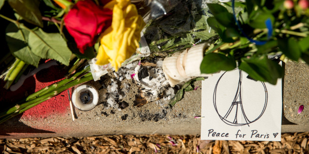 Mourners leave flowers and cards outside the gates of the French Embassy in Washington, Sunday, Nov. 15, 2015. The Islamic State group claimed responsibility for Friday's attacks on a stadium, a concert hall and Paris cafes that left more than 120 people dead and over 350 wounded. (AP Photo/Andrew Harnik)