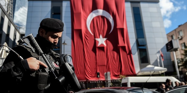 A Turkish riot policeman stands guard outside the headquarters of Bugun newspaper and Kanalturk television station in Istanbul during a protest against the Turkish government's crackdown on media outlets on October 28, 2015. Riot police firing tear gas and water cannon stormed the Istanbul headquarters of a media group linked to President Recep Tayyip Erdogan's bitter rival, on what was described as a dark day for democracy ahead of a pivotal election. The action triggered widespread concern about media freedom in Turkey, with critics accusing the government of trying to silence opponents of Erdogan's Justice and Development Party (AKP) before the November 1 legislative vote. AFP PHOTO / OZAN KOSE (Photo credit should read OZAN KOSE/AFP/Getty Images)
