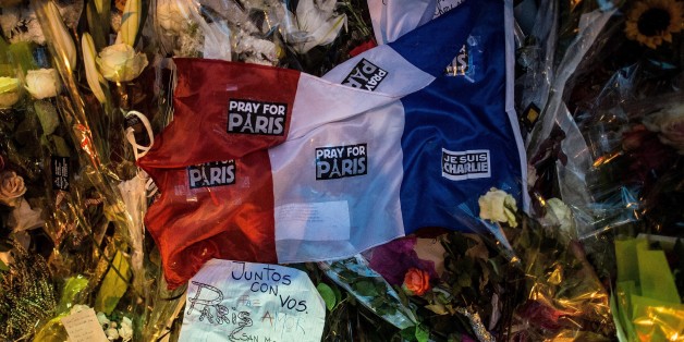 PARIS, FRANCE - NOVEMBER 16: A French flag lays on flowers in memory of the victims of Friday's attack in front of Bataclan concert hall on November 16, 2015 in Paris, France. A Europe-wide one-minute silence was held at 12pm CET today in honour of at least 129 people who were killed last Friday in a series of terror attacks in the French capital. (Photo by David Ramos/Getty Images)