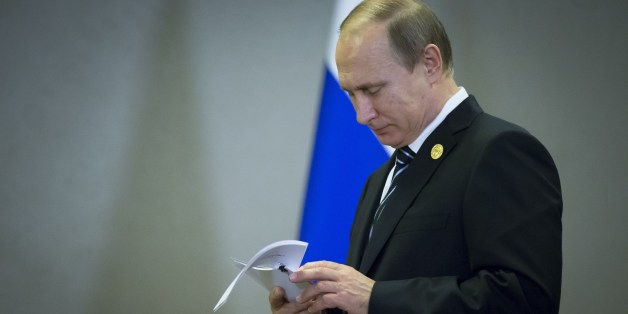 FILE - In this Monday, Nov. 16, 2015 file photo, Russian President Vladimir Putin reads his notes waiting for British Prime Minister David Cameron for their talks at the G-20 Summit in Antalya, Turkey. For President Vladimir Putin, the terror attacks in Paris marked a watershed moment in relations with the West. This weekâs summit in Turkey made it clear that the U.S. and its allies have warmed to the idea of closer ties with Russia, whose help they need to confront the challenge of the Isl