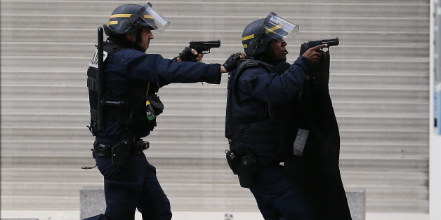 Armed police operate in Saint-Denis, a northern suburb of Paris, Wednesday, Nov. 18, 2015. Police say two suspects in last week's Paris attacks, a man and a woman, have been killed in a police operation north of the capital. Two police officers have been injured in the standoff. Police have said the operation is targeting the suspected mastermind of last week's attacks, believed to be holed up in an apartment in Saint-Denis with several other heavily armed suspects. (AP Photo/Francois Mori)